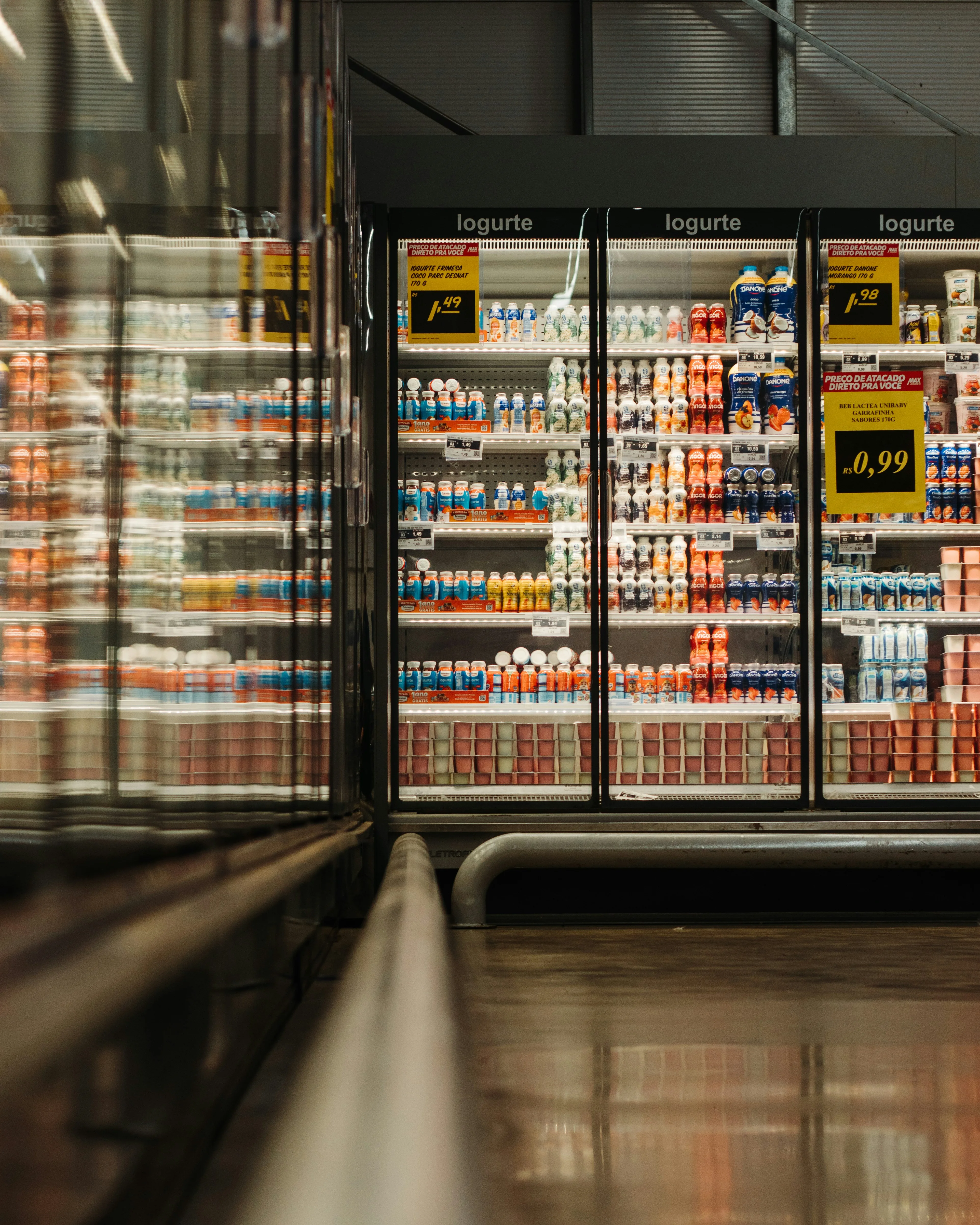 Illuminated dairy refrigerator cases stocked with yogurt and chilled products in supermarket