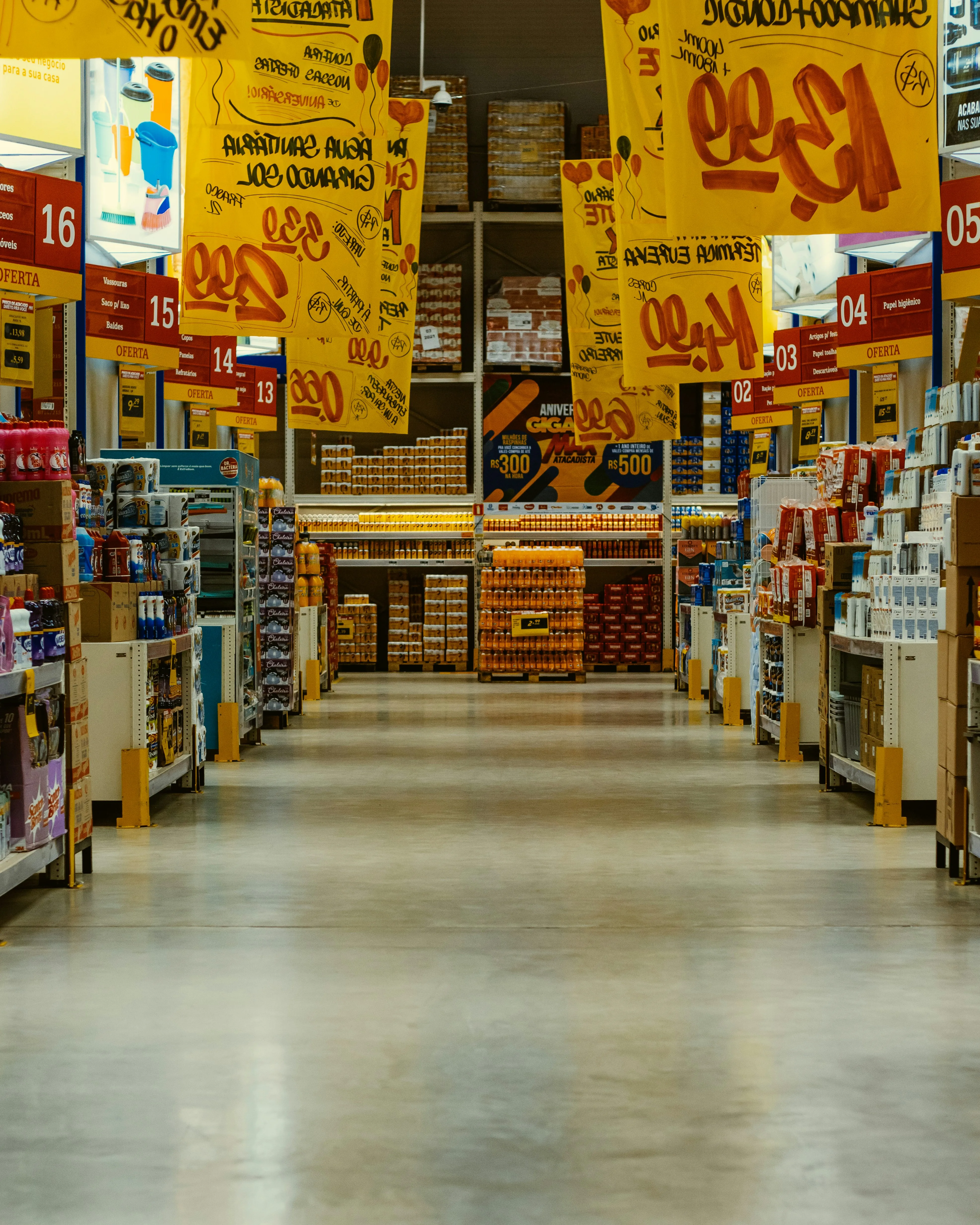 Wide supermarket aisle with promotional banners and bulk consumer products