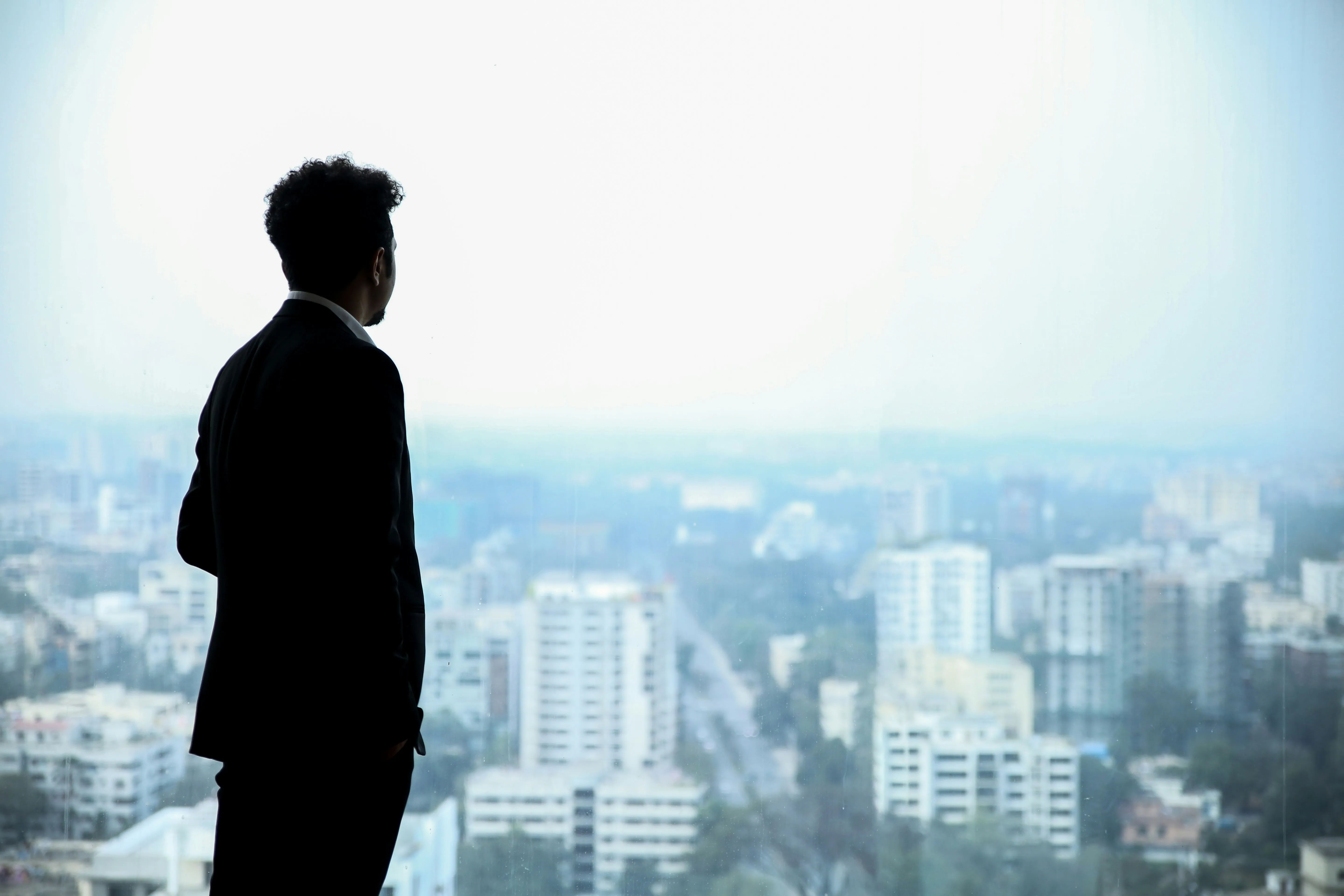Executive overlooking city skyline from high-rise office