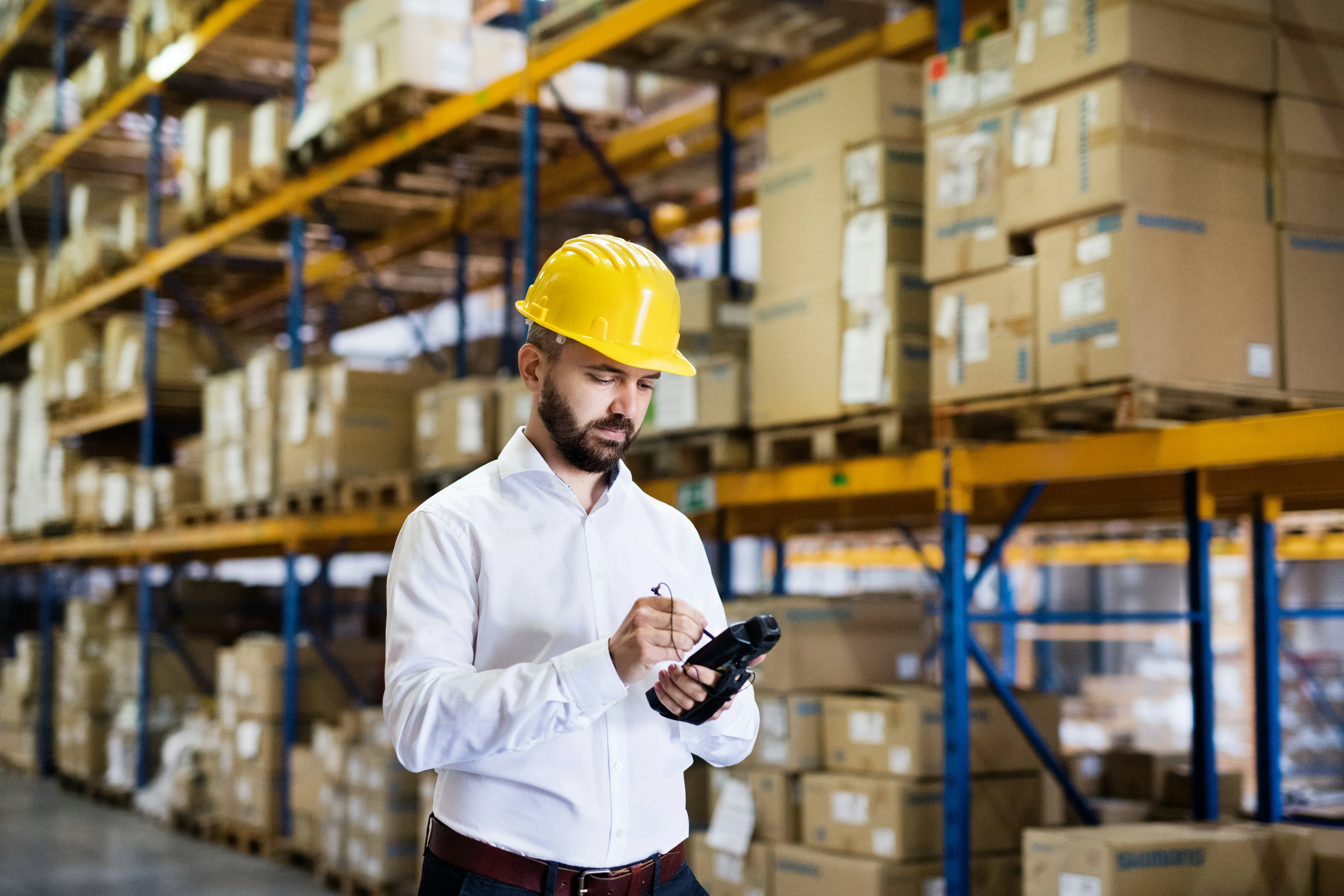 Warehouse manager using barcode scanner among inventory