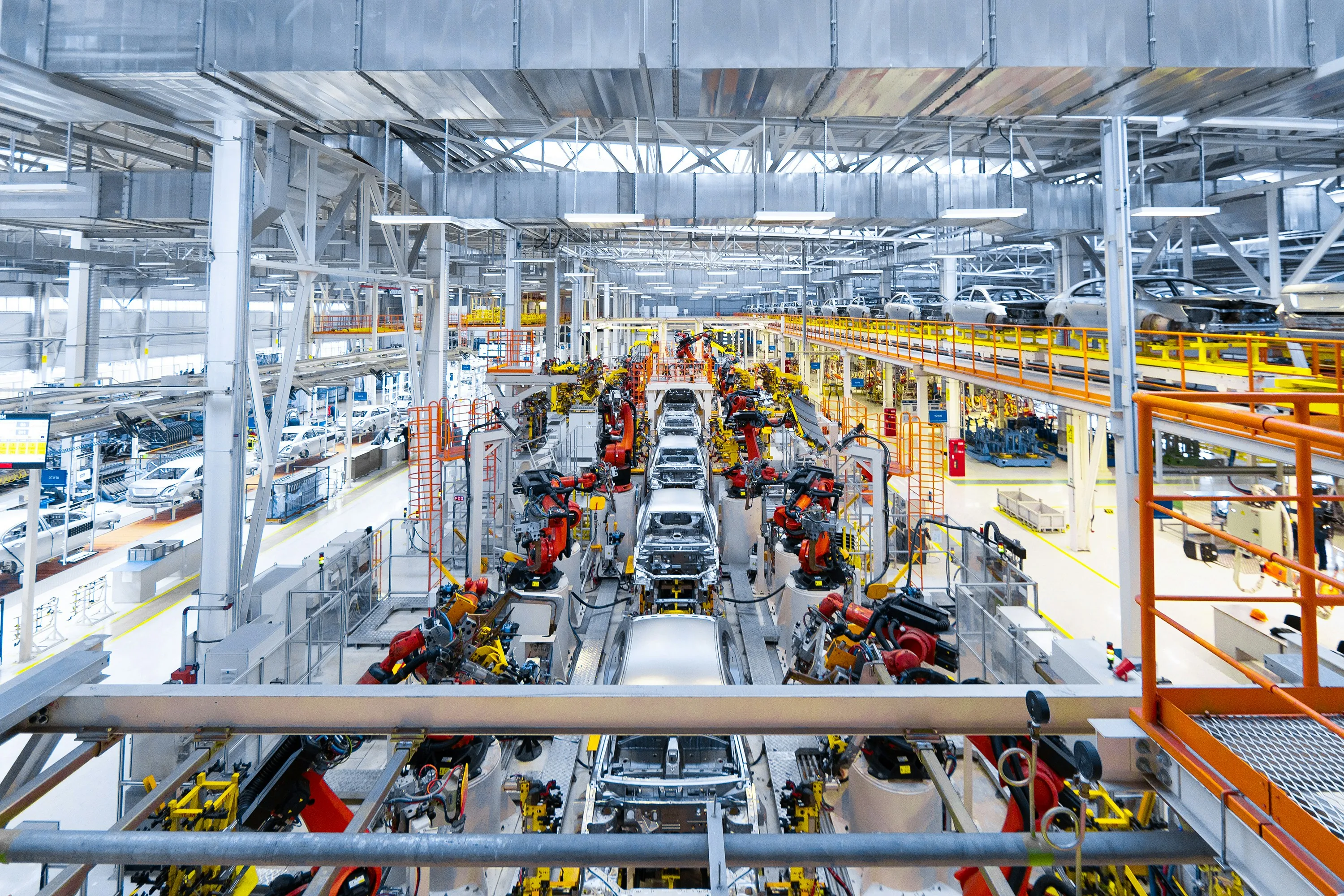 Modern automotive assembly plant with robotic arms on production line