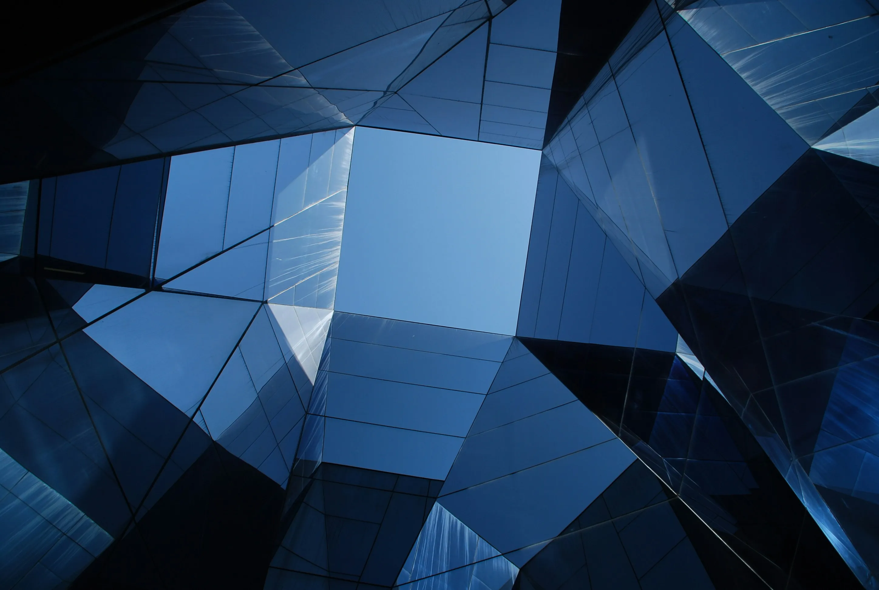 Abstract geometric glass architecture with deep blue angular panels