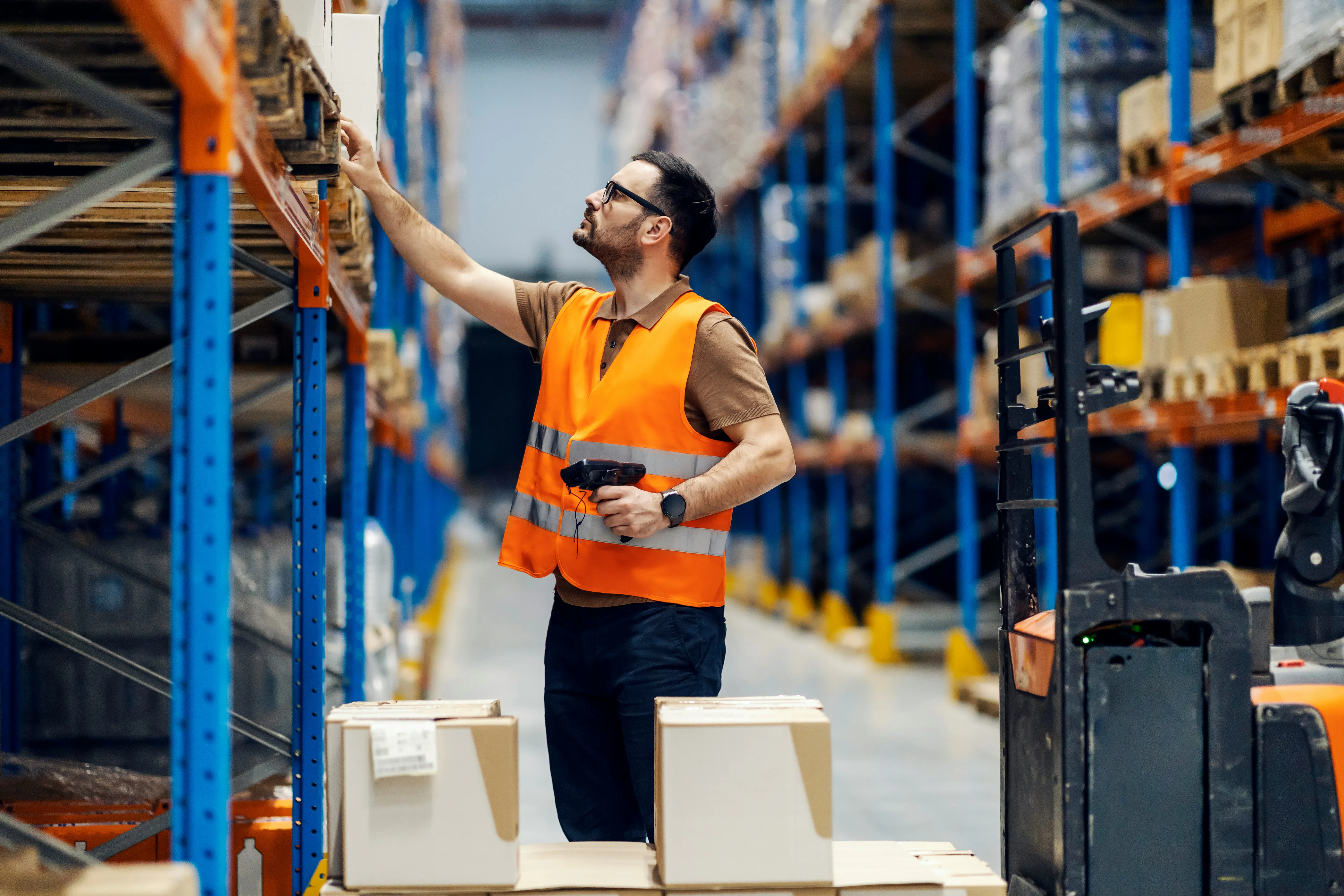 Warehouse worker picking from shelves with barcode scanner