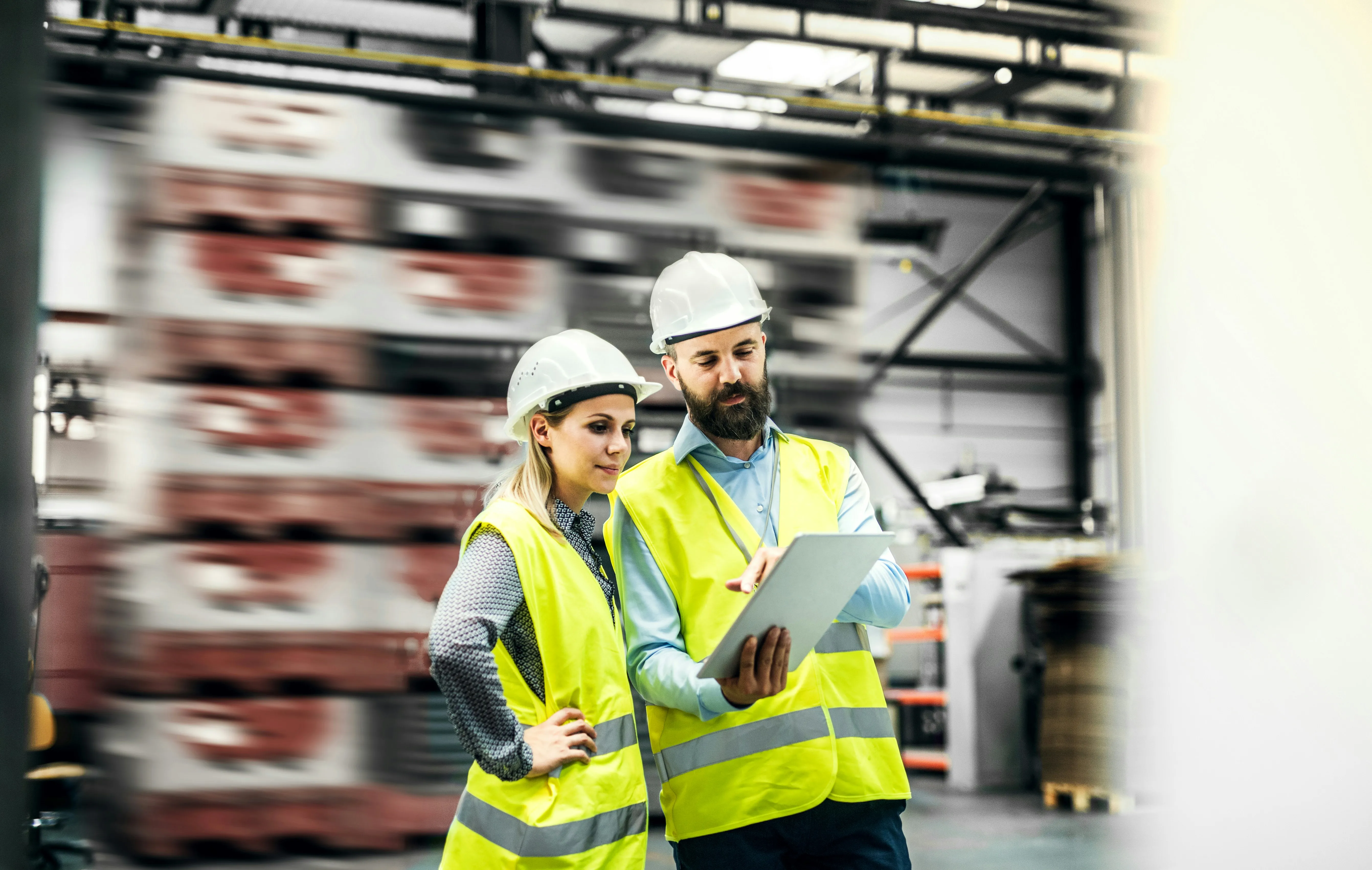 Two workers reviewing operations on laptop in distribution center