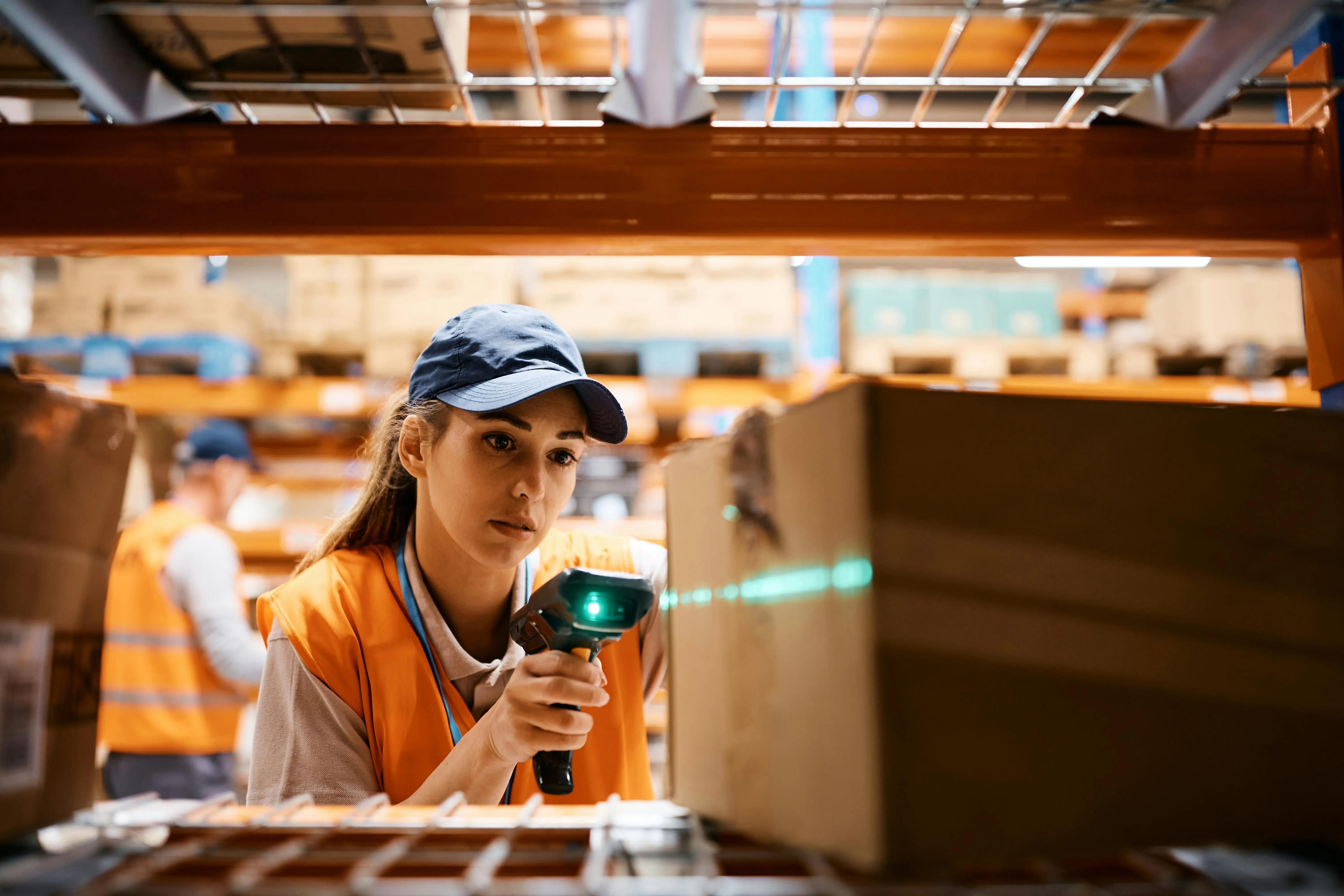 Woman scanning packages with barcode scanner in warehouse